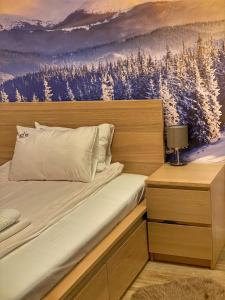 科帕奥尼克Silver Kop apartmani的一间卧室配有一张带雪覆盖树木绘画的床。 更多45张照片