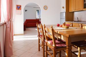 a kitchen with a wooden table with chairs and a dining room at Casa Angelo in Molveno