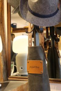 un sombrero y una bolsa delante de un espejo en Auberge du Grand Champ en Lalley