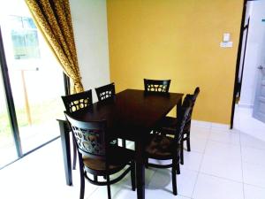 een eetkamer met een zwarte tafel en stoelen bij D'View Guest Houses in Kuala Perlis