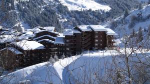 un grand bâtiment dans la neige avec une montagne dans l'établissement Ski in and Out 2-Bed Apartment in Meribel, à Les Allues
