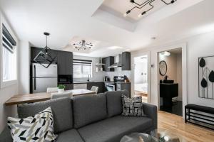 a living room with a gray couch and a kitchen at Complexe LIVTremblant by Gestion ELITE - LIV2 in Mont-Tremblant