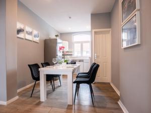 een keuken en eetkamer met een witte tafel en zwarte stoelen bij Charmantes Apartment in Hannover in Hannover