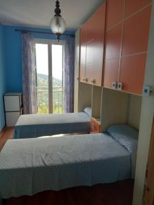 a bedroom with two beds and a window with a view at Casa Vita in Vallebona