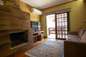 sala de estar con sofá y chimenea en Morada do Lago - My Home Temporada, en Gramado