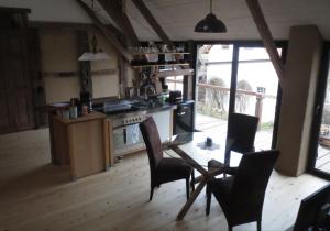 a kitchen with a table and chairs and a stove at Heidi´s Gästezimmer in Lippstadt