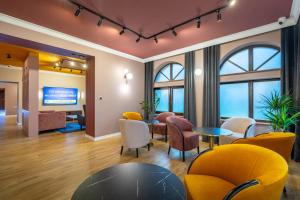 a waiting room with chairs and tables and a tv at Pensjonat Carmen in Szklarska Poręba