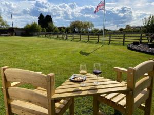 una mesa de picnic de madera con 2 copas de vino en Ye Old Tack Room, en Stafford