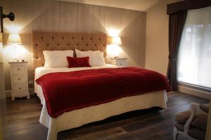 a bedroom with a large bed with a red blanket at Pomegranate Guest House in Healesville