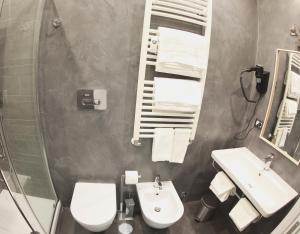 a bathroom with a toilet and a sink and a mirror at WE LOVE ROMA Guest House in Rome