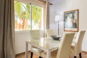 d'une salle à manger avec une table, des chaises et une fenêtre. dans l'établissement Apartamentos Nicaragua, à Benidorm