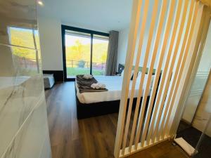 a bedroom with a bed and a large window at Dobau casas in Vieira do Minho