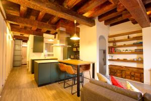 cocina con techos de madera, mesa y sofá en Cuencaloft Vigas del Sire, en Cuenca