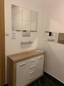 een badkamer met witte kasten en een spiegel bij Noclegi-Apartamenty Kłodzko Verona in Kłodzko