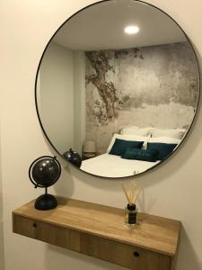 um espelho numa parede com uma cama num quarto em Marquês d'Aveiro Suite em Aveiro