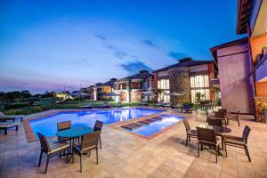 a patio with a table and chairs next to a pool at Royal Marang Hotel in Phokeng