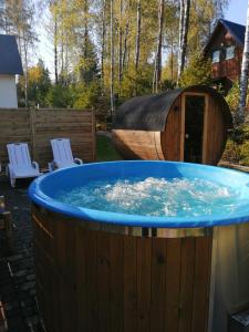 a large wooden tub with a wooden boat in a yard at Domek Julia z banią ruską i sauną in Sulęczyno