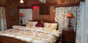 a bedroom with a bed with two lamps and curtains at House Boat Hardy Palace in Srinagar