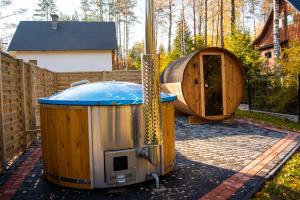 a hot tub and a wooden iguana in a backyard at Domek Julia z banią ruską i sauną in Sulęczyno