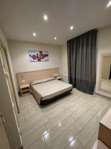 a bedroom with a bed and a tiled floor at Hotel San Biagio in Milan