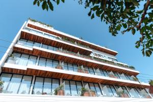 an apartment building with potted plants on the balconies at CALIXTA Hotel in Playa del Carmen