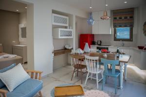 eine Küche und ein Wohnzimmer mit einem Tisch und Stühlen in der Unterkunft Almyra Seaside House Mochlos in Mochlos