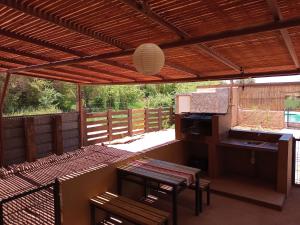 a patio with a wooden roof with a table and chairs at Cabañas el Chañar in San Pedro de Atacama