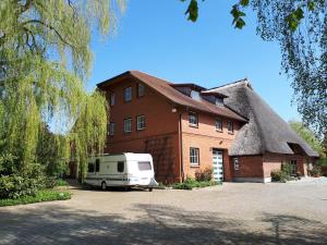 a van parked in front of a house with a thatch roof at Kleines Paradies 