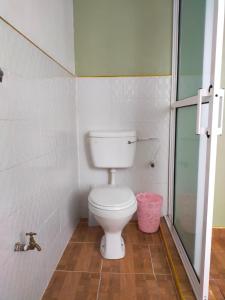 a bathroom with a toilet and a glass shower at Bloom 2 private home in Thika