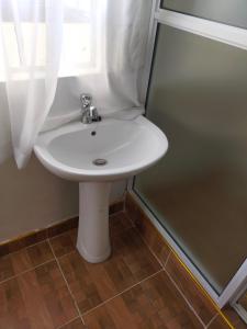 lavabo blanco en un baño con ventana en Bloom 2 private home, en Thika
