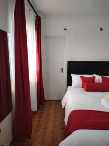 a bedroom with two beds and red curtains at Bloom 2 private home in Thika