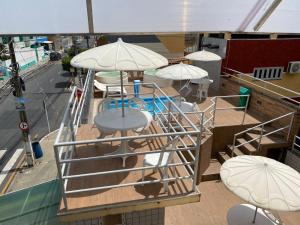 a deck of a cruise ship with tables and umbrellas at Pousada Panorâmica in Aracaju