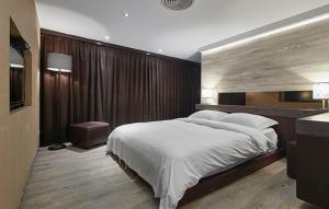 1 dormitorio con 1 cama grande y TV en JBG Hotspring Resort Hotel en Taipéi