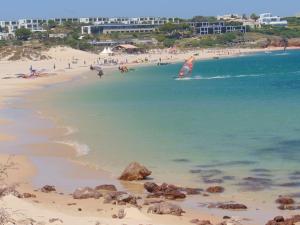 a beach with a group of people in the water at Casa da Praia in Sagres