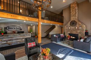 a living room with a fireplace and a staircase at Breck Inn in Breckenridge