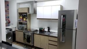 een keuken met een roestvrijstalen koelkast en een vaatwasser bij Apartamento aconchegante à 200m Praia de Piçarras in Piçarras