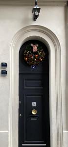 a black door with areath on a building at Les Berceaux de la Cathedrale in Reims