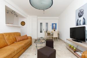 a living room with a couch and a tv at LUXURY APARTMENT between ANTIBS and CROISETTE in Cannes