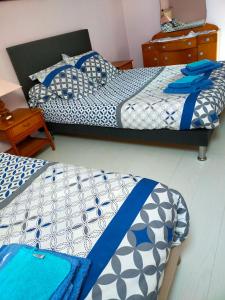 two beds in a room with blue and white at La petite maison bleue in Lopérec