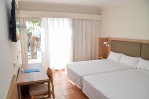 a hotel room with a bed and a desk at PLAYABALLENA SPA HOTEL in Costa Ballena