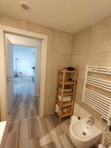 uma casa de banho com um lavatório, um WC e uma prateleira em Grazioso Monolocale Milano em Milão