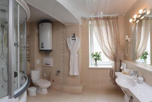 La salle de bains est pourvue de toilettes, d'un lavabo et d'une douche. dans l'établissement Vizavi Apartments, à Iekaterinbourg