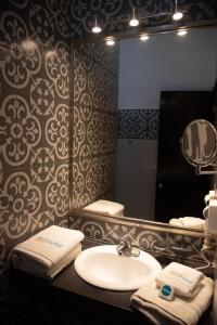 W łazience znajduje się umywalka i lustro. w obiekcie Aparthotel Siete 32 w mieście Mérida