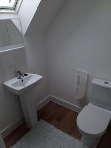 bagno con servizi igienici bianchi e lavandino di Guest House - oxfordshire a Banbury