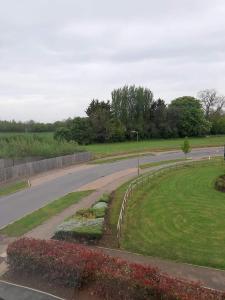 an empty road in a park next to a field at Guest House - oxfordshire in Banbury