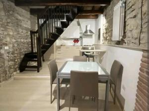 a dining room with a glass table and chairs at Narnia Loft in Narni