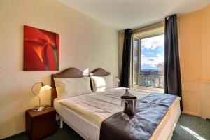 a bedroom with a bed and a large window at Hôtel Restaurant Bellevue in Onnens