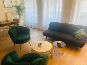 uma sala de estar com um sofá, cadeiras e uma mesa em SPA de charme 6 pers avec Jacuzzi & Sauna privatifs au coeur de ville - Esprit Coco em Mulhouse