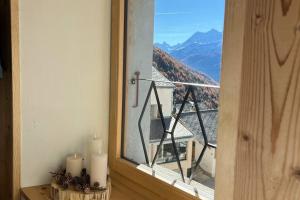 a window with two candles and a view of a mountain at L’alpazo St-Luc in Saint-Luc