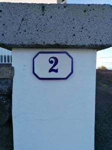 a sign with the number two on the side of a building at Casa da Isabel in São Roque do Pico